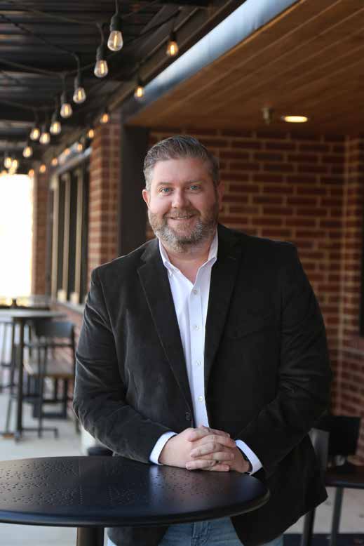 Todd Bingham seated at a table for his Real Producers profile